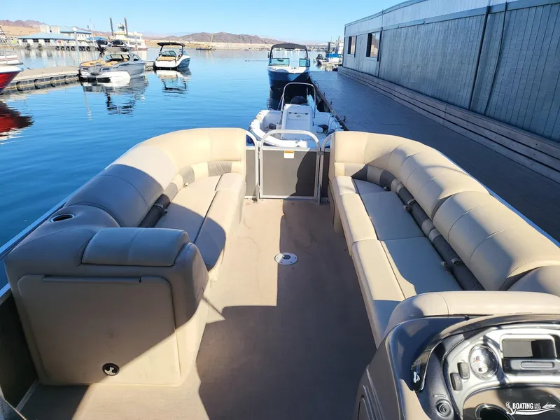 Slide: The Image of 2020 Tracker Party Barge 24 DLX pontoon boat with spacious seating at a marina. - 7
