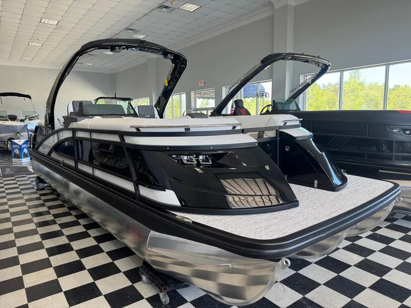 Slide: The Image of 2025 Bennington 25QFBA pontoon boat displayed indoors on checkered floor. - 1