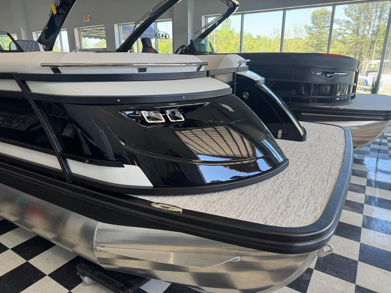 Slide: The Image of 2025 Bennington 25QFBA pontoon boat displayed indoors on checkered floor. - 3