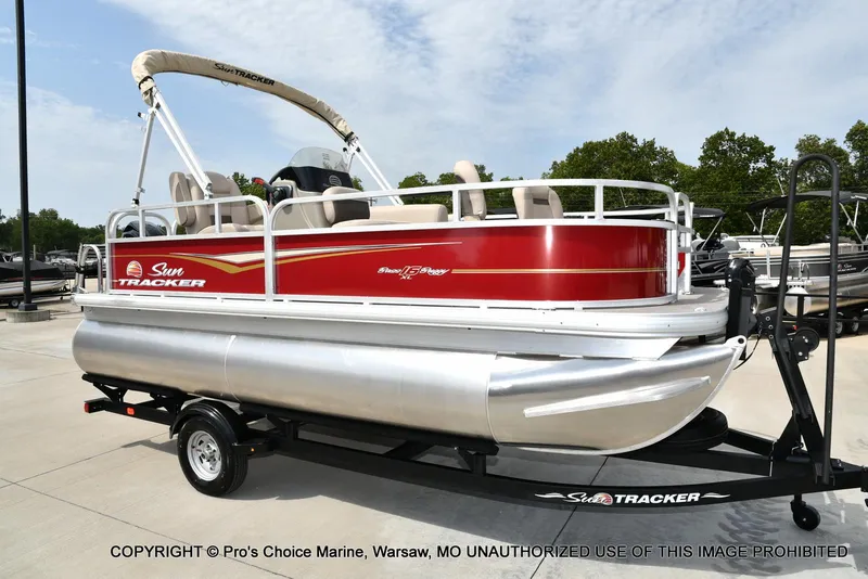 Slide: The Image of 2025 Sun Tracker Bass Buggy 16 DLX pontoon boat on trailer, red and white design. - 47