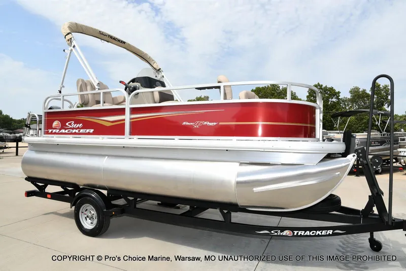 Slide: The Image of 2025 Sun Tracker Bass Buggy 16 DLX pontoon boat on trailer, red and silver design. - 49