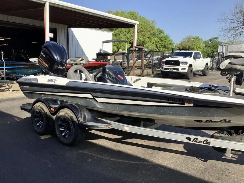 Slide: The Image of 2018 Bass Cat Panterra II boat on trailer, parked near a white truck. - 13