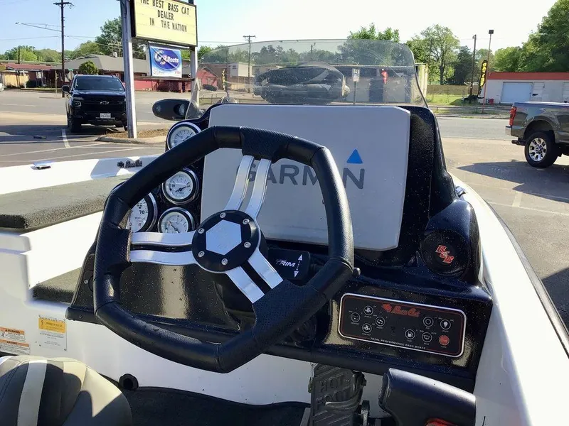 Slide: The Image of 2018 Bass Cat Panterra II boat dashboard with steering wheel and Garmin display. - 18