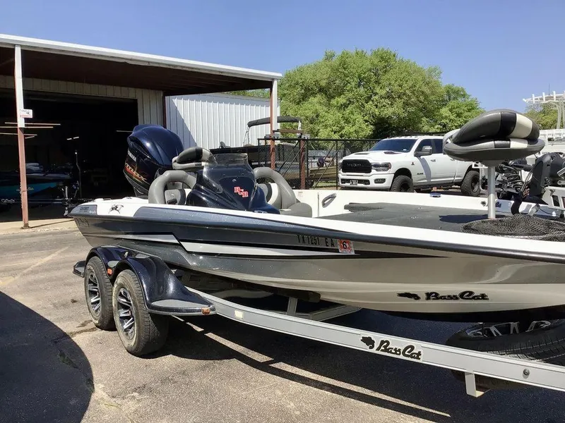 Slide: The Image of 2018 Bass Cat Panterra II boat on trailer, parked near a garage and white truck. - 37