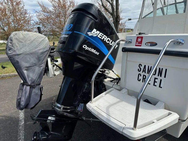 Slide: The Image of 2002 Trophy boat with Mercury OptiMax outboard motor, parked outdoors. - 12