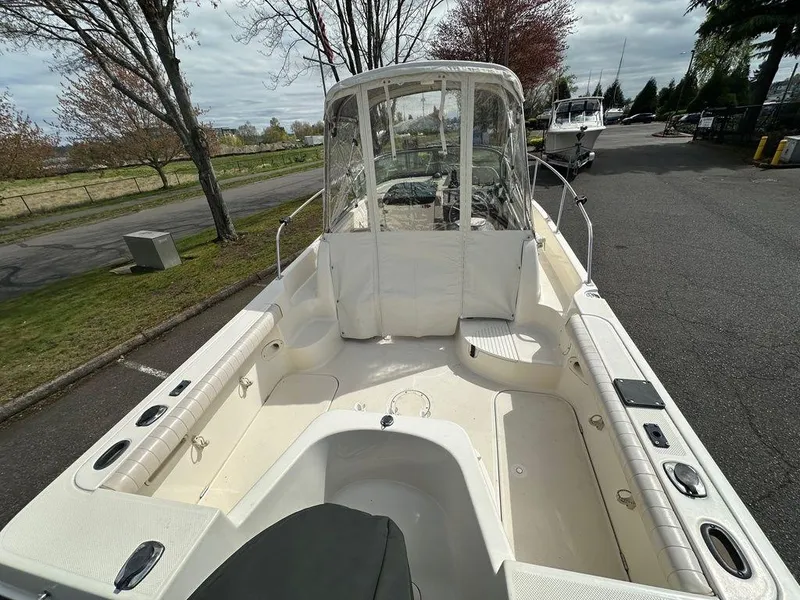 Slide: The Image of 2002 Trophy boat with spacious deck and seating, parked on a tree-lined road. - 5