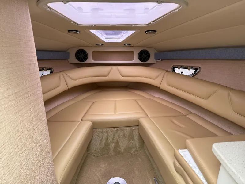 Slide: The Image of Interior of a 2013 Cobalt 273 boat with beige leather seating and overhead skylight. - 15