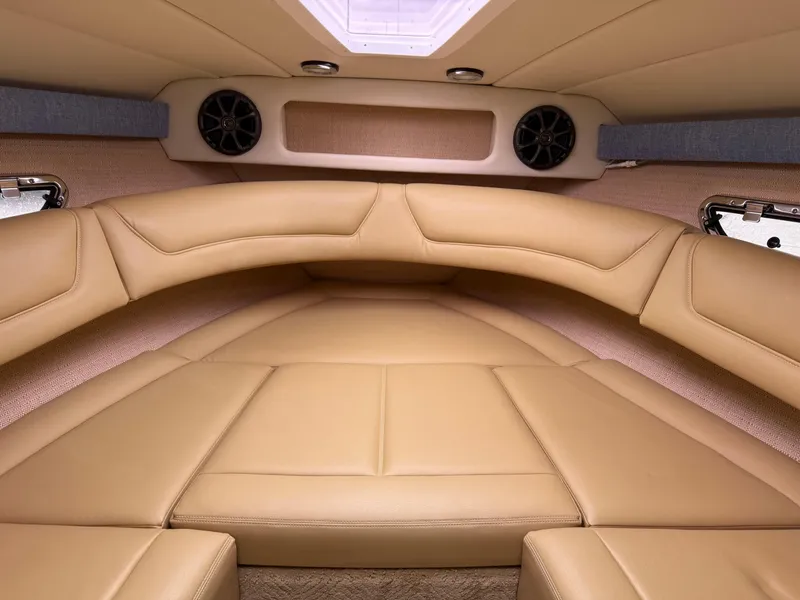 Slide: The Image of Interior of a 2013 Cobalt 273 boat with tan leather seating and speakers. - 16