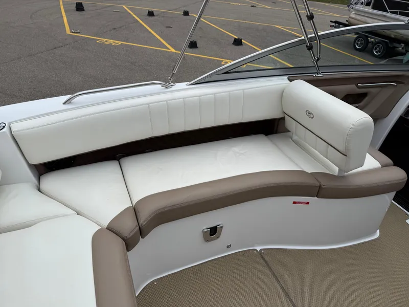 Slide: The Image of 2013 Cobalt 273 boat interior with white and brown seating in a parking lot. - 19
