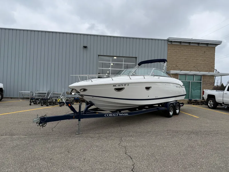 Slide: The Image of 2013 Cobalt 273 boat on trailer in parking lot, overcast sky. - 2