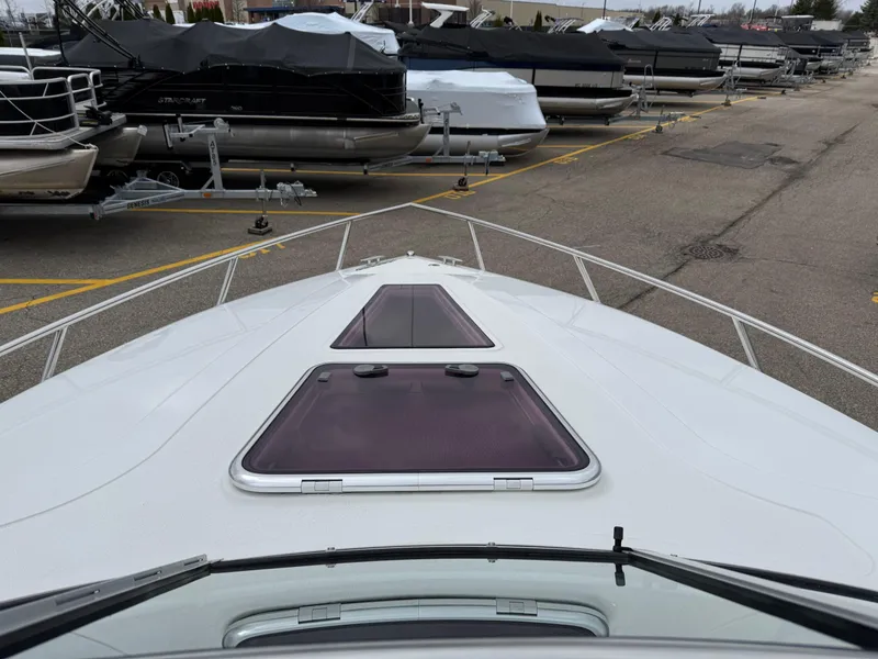 Slide: The Image of 2013 Cobalt 273 boat bow view in a marina with covered boats. - 21