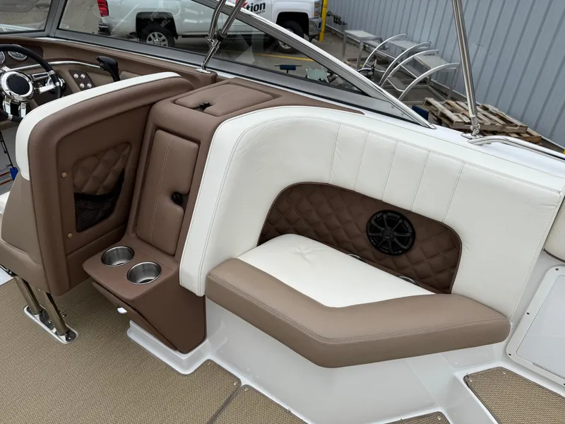 Slide: The Image of 2013 Cobalt 273 boat interior with brown and white seating, cup holders, and speaker. - 9