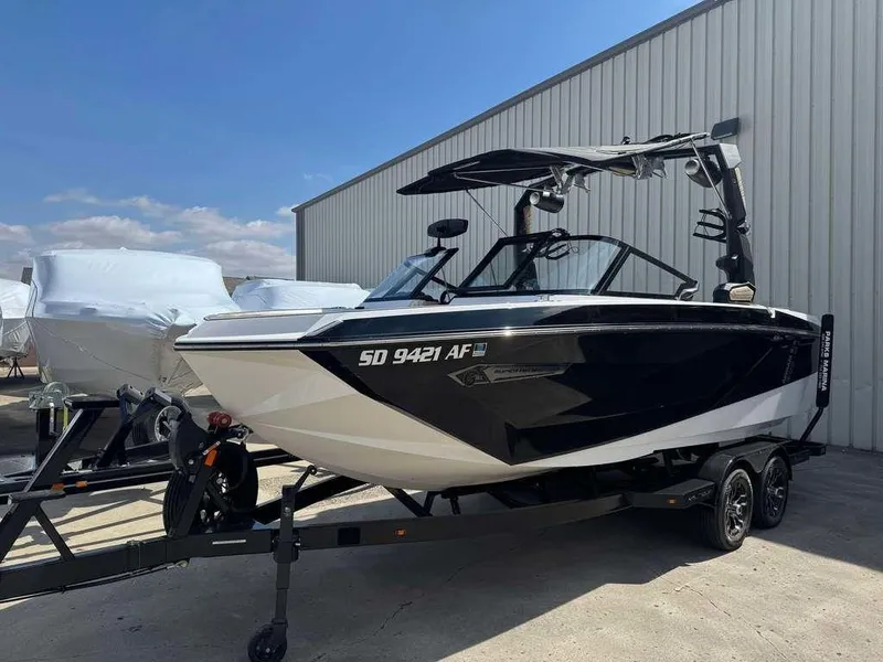 Slide: The Image of 2022 Nautique Super Air Nautique G21 boat on trailer, parked outdoors. - 2