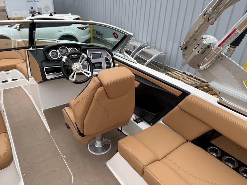 Slide: The Image of 2018 MasterCraft XT23 boat interior with tan seats and modern dashboard. - 10