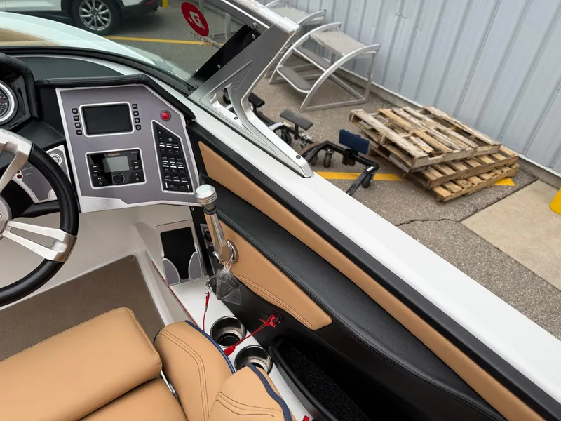 Slide: The Image of 2018 MasterCraft XT23 boat interior with dashboard and tan seating. - 12