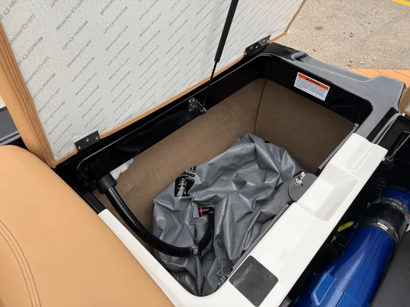 Slide: The Image of Open storage compartment in 2018 MasterCraft XT23 boat, showing interior details and components. - 19