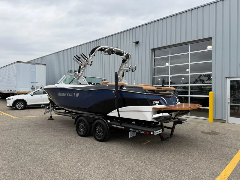 Slide: The Image of 2018 MasterCraft XT23 boat on trailer outside a warehouse. - 3