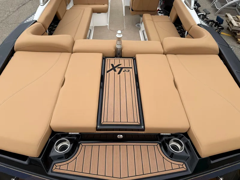 Slide: The Image of 2018 MasterCraft XT23 boat interior with tan seating and teak flooring. - 8