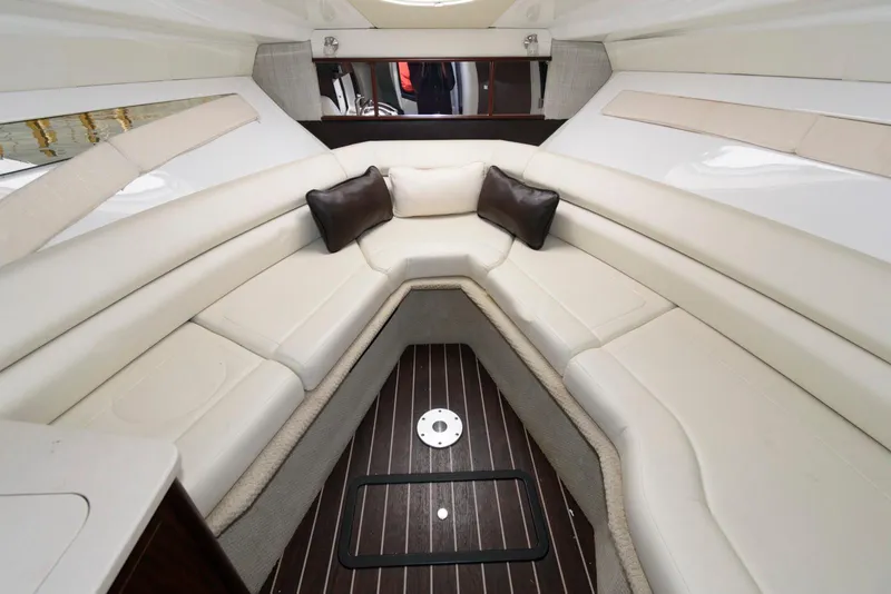 Slide: The Image of 2019 Monterey 295 Sport Yacht interior with white seating and wood flooring. - 12