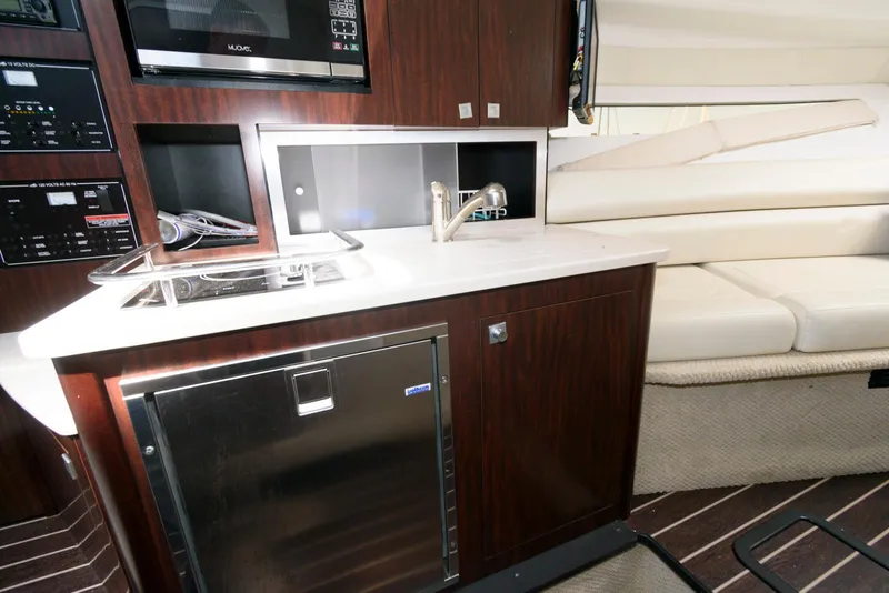 Slide: The Image of 2019 Monterey 295 Sport Yacht interior with kitchenette and seating area. - 14