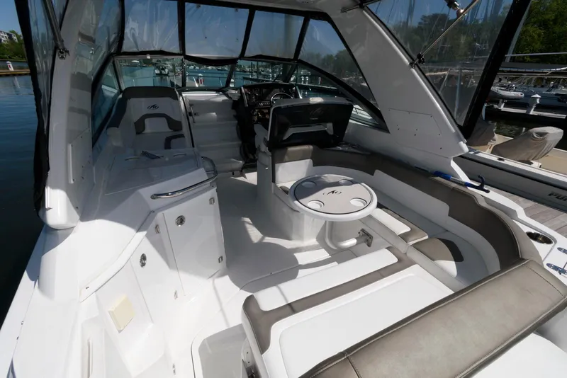 Slide: The Image of 2019 Monterey 295 Sport Yacht interior with seating and helm, docked at marina. - 3