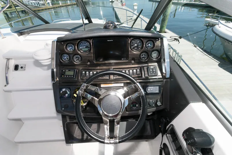 Slide: The Image of Cockpit of 2019 Monterey 295 Sport Yacht with steering wheel and control panel. - 8