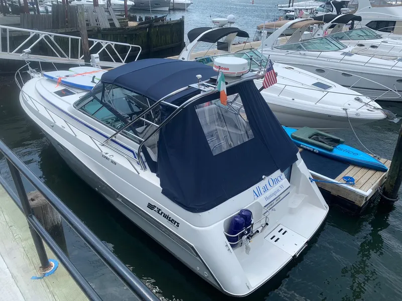 Slide: The Image of 1989 Cruisers Yachts 3670 Esprit docked, featuring a blue canopy and sleek design. - 2