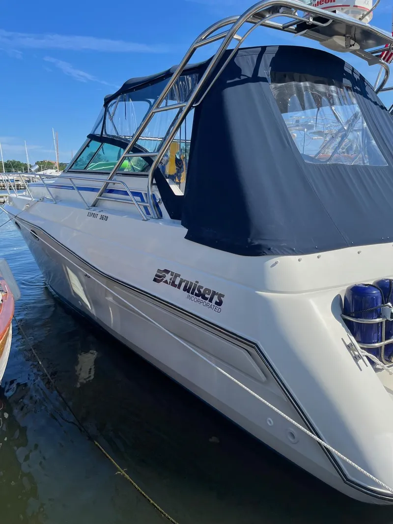 Slide: The Image of 1989 Cruisers Yachts 3670 Esprit docked, featuring a sleek design and blue canopy. - 6