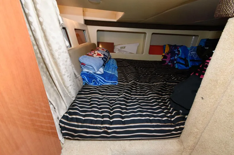 Slide: The Image of 2008 Maxum 2900 SE cabin interior with striped bedding and folded towels. - 14