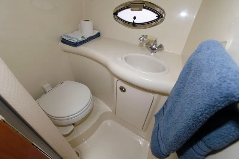Slide: The Image of 2008 Maxum 2900 SE boat bathroom with sink, toilet, and porthole window. - 15