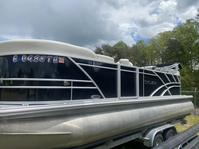Slide: The Image of 2023 Sylvan 822 LZ Mirage pontoon boat on trailer, under cloudy sky. - 1