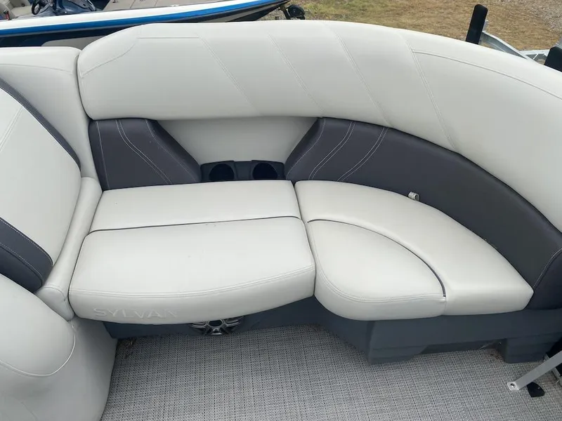 Slide: The Image of 2023 Sylvan 822 LZ Mirage boat interior with white and gray cushioned seating. - 12