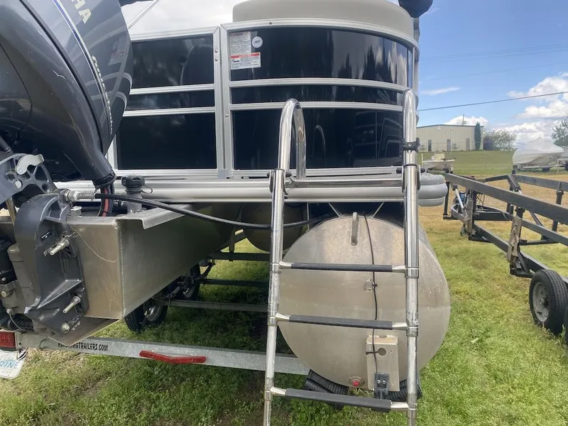 Slide: The Image of 2023 Sylvan 822 LZ Mirage pontoon boat with Yamaha motor and ladder on grassy area. - 16