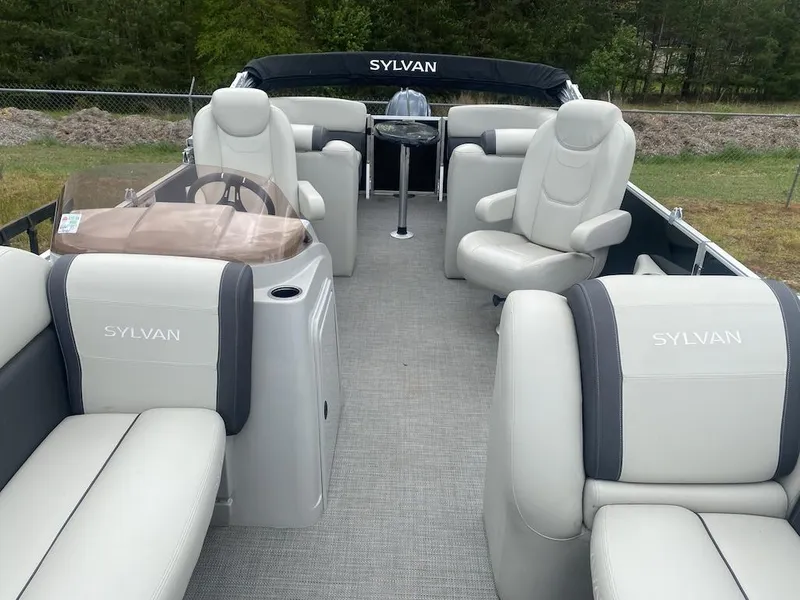 Slide: The Image of 2023 Sylvan 822 LZ Mirage pontoon boat interior with plush seating and steering console. - 2
