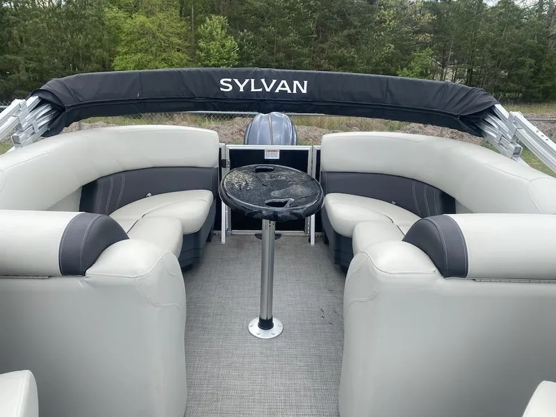 Slide: The Image of 2023 Sylvan 822 LZ Mirage pontoon boat interior with plush seating and table. - 3