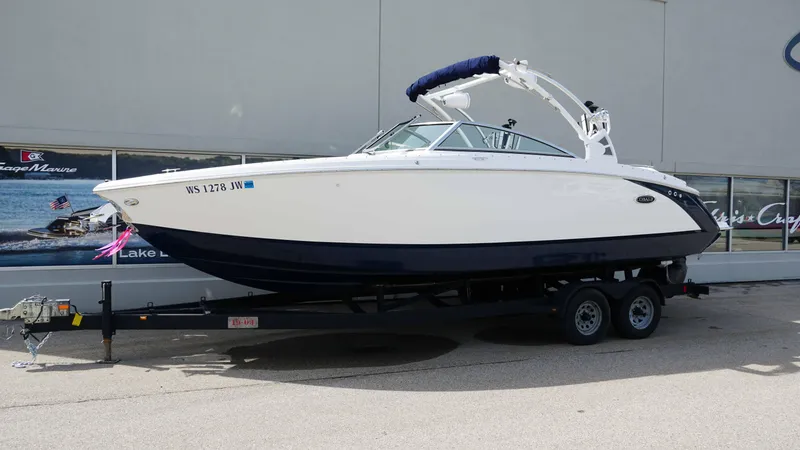 Slide: The Image of 2019 Cobalt R7 boat on trailer, white and navy design, parked outdoors. - 1