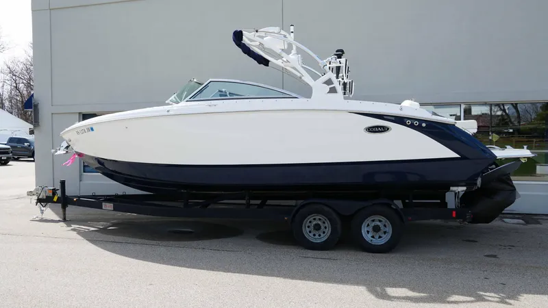 Slide: The Image of 2019 Cobalt R7 boat on trailer, white and blue design, parked outdoors. - 3