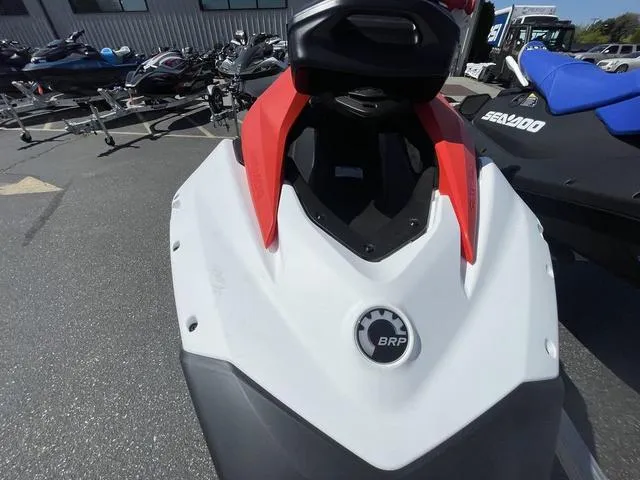 Slide: The Image of 2025 Sea-Doo Spark Trixx Waverunner, red and white, parked outdoors. - 11