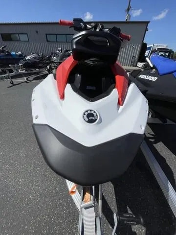 Slide: The Image of 2025 Sea-Doo Spark Trixx Waverunner, red and white, parked outdoors on a trailer. - 12