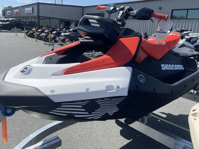Slide: The Image of 2025 Sea-Doo Spark Trixx Waverunner, red and white, displayed outdoors on a trailer. - 13