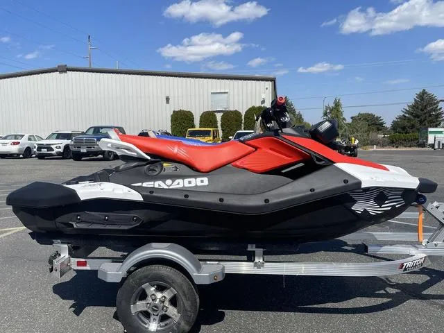 Slide: The Image of 2025 Sea-Doo Spark Trixx jet ski on trailer, parked outdoors under blue sky. - 3