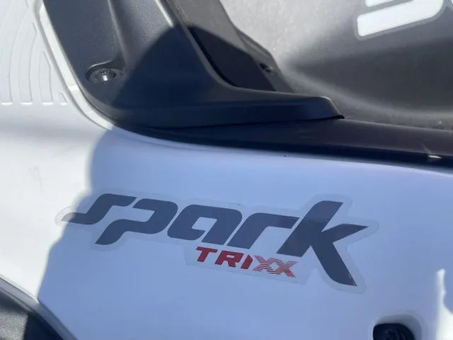 Slide: The Image of 2025 Sea-Doo Spark Trixx logo on white body, close-up view. - 4