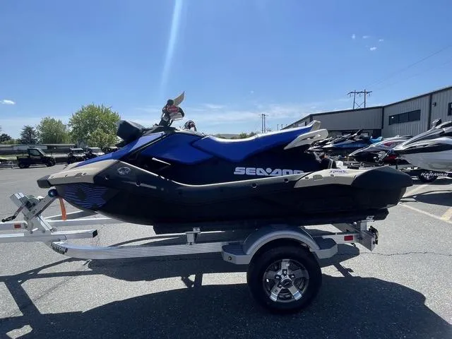 Slide: The Image of 2025 Sea-Doo Spark Trixx jet ski on trailer under clear blue sky. - 3