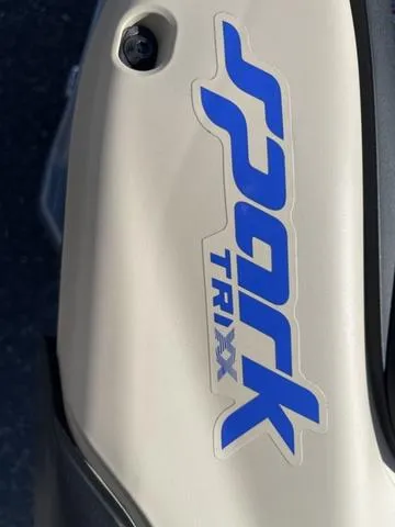 Slide: The Image of 2025 Sea-Doo Spark Trixx logo on beige body, close-up view. - 9