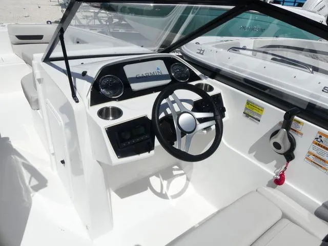 Slide: The Image of 2023 Hurricane SunDeck 235 OB boat cockpit with steering wheel and Garmin display. - 10