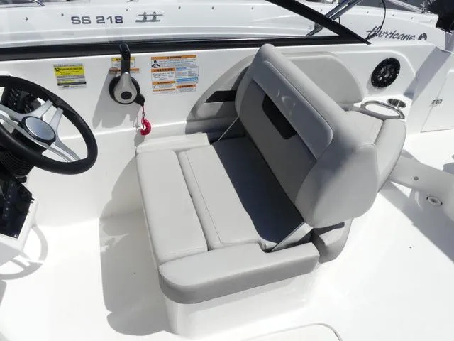 Slide: The Image of 2023 Hurricane SunDeck 235 OB boat interior with gray seating and steering wheel. - 11