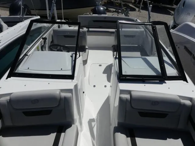 Slide: The Image of 2023 Hurricane SunDeck 235 OB boat interior with open windshield and seating area. - 19