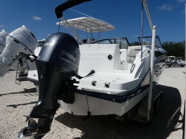 Slide: The Image of 2023 Hurricane SunDeck 235 OB boat with Yamaha outboard motor, parked on gravel. - 6