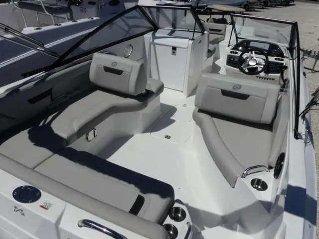 Slide: The Image of 2023 Hurricane SunDeck 235 OB boat interior with spacious seating and modern dashboard. - 7