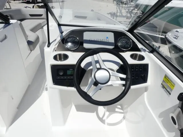 Slide: The Image of 2023 Hurricane SunDeck 235 OB boat cockpit with steering wheel and Garmin display. - 9